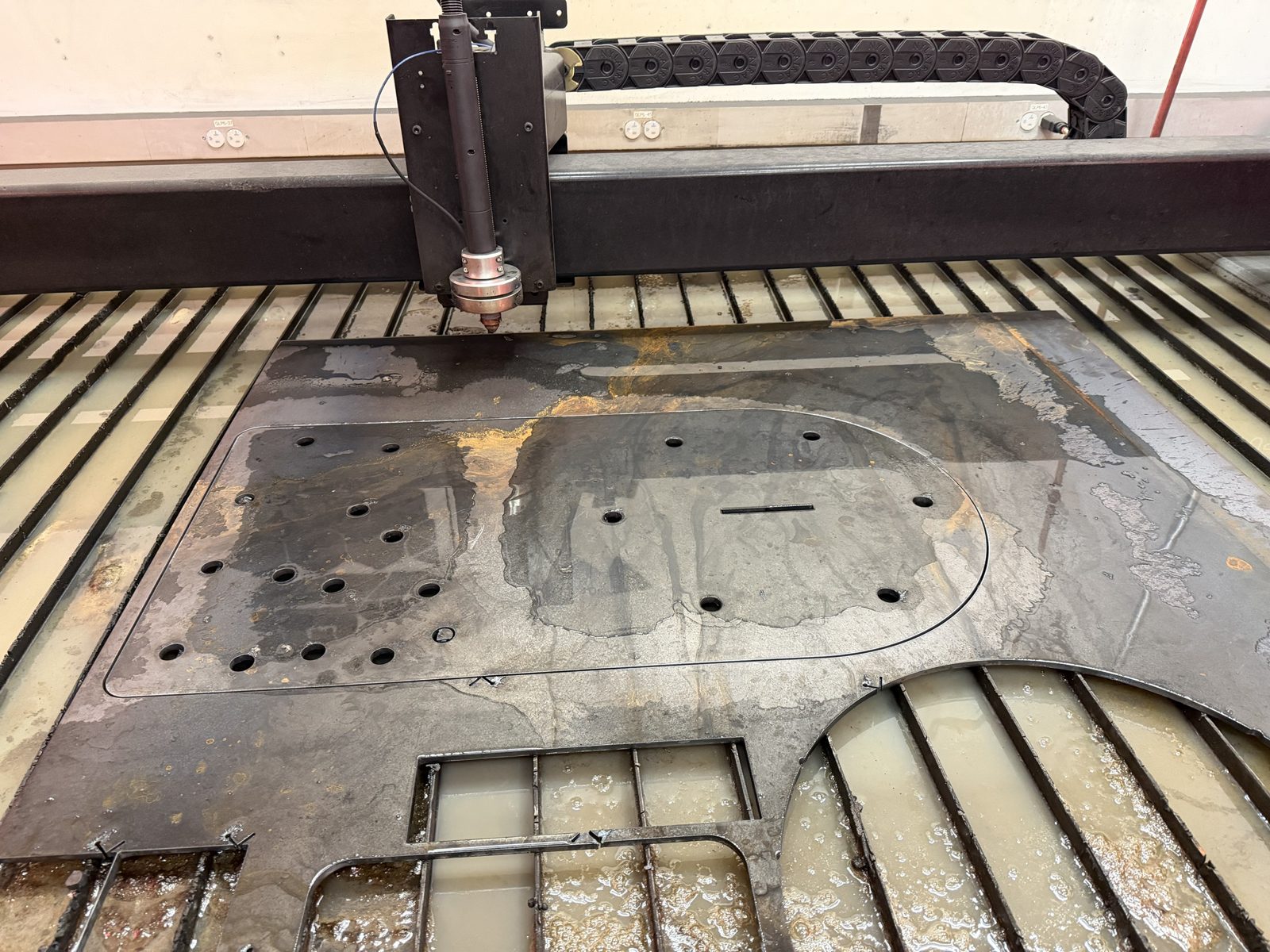 CNC plasma table cutting the sundial backing plate from steel