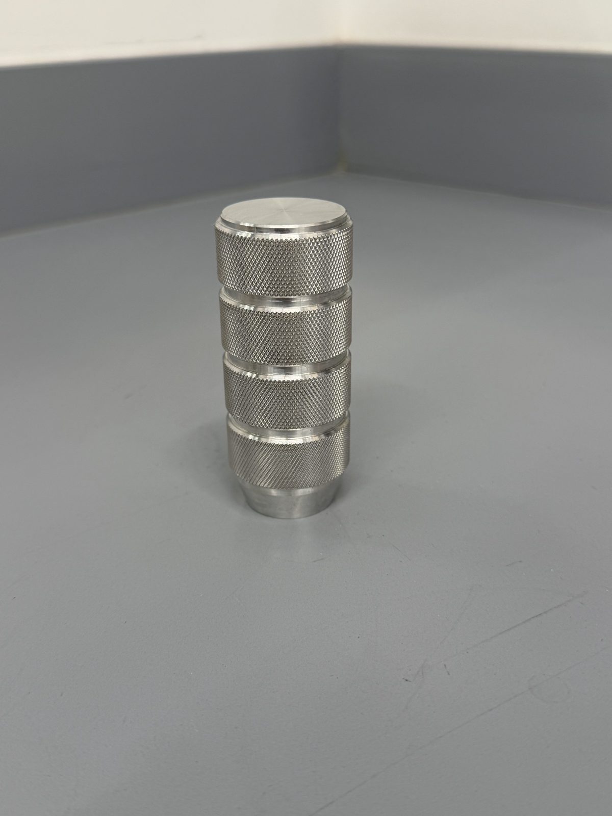 Shift knob standing upright, showing four knurled bands
