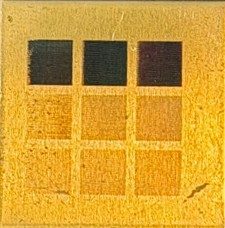 Brass sample with a three-by-three grid of laser-textured squares
